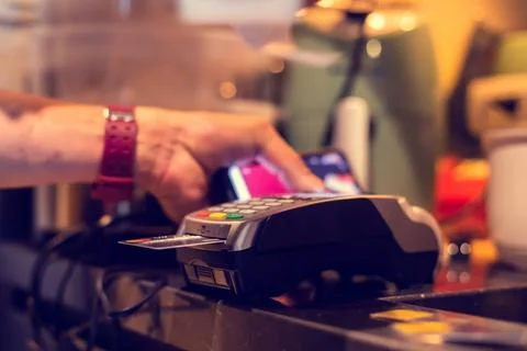 Selective focus to credit card reader with blurry hand pull slip for payment. Stock Photos