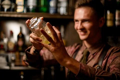 Selective focus of crystal shaker with cocktail in male hands. Stock Photos