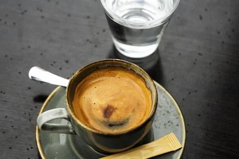 Selective focus on cup of coffee and glass of water. Close up Stock Photos