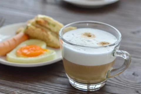 Selective focus cup of coffee on table and blur breakfast background. Stock Photos