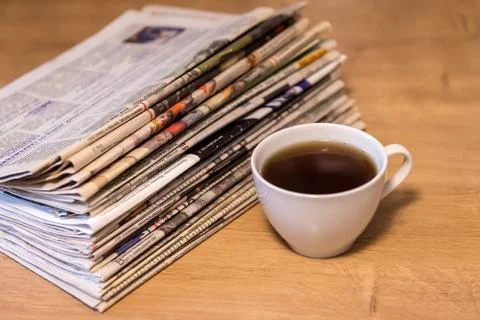 Selective focus of the cup of tea stacking newspapers folded place on wooden 库存照片