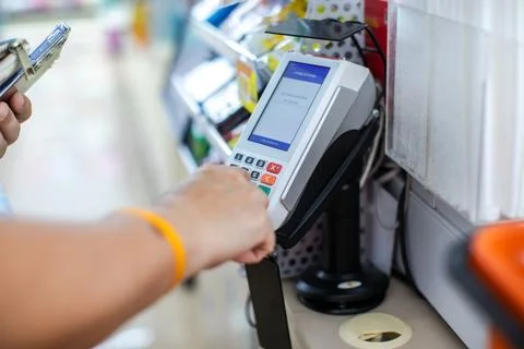 Selective focus to Customer Entering PIN Code on POS Terminal Machine in Stor Stock Photos