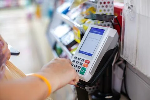 Selective focus to Customer Entering PIN Code on POS Terminal Machine in Stor Stock Photos
