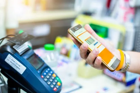 Selective focus to customer hand hold smartphone to payment in shop. Stockfoto's