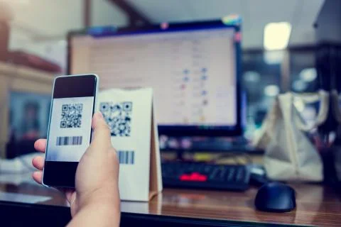 Selective focus to customer hand holding smart phone to scan Qr code payment  Stockfoto's