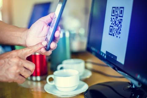 Selective focus to customer scan QR code to payment at cash register machine. Stockfoto's