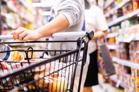 Selective focus to Customer's hand is pushing a shopping cart Stock Photos