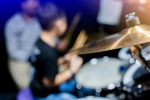 Selective focus to cymbals of drum set with blurry kid learning and play drum Stock Photos