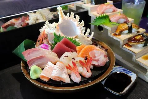 Selective focus decorated sashimi set in a bowl with ice and conch shell anot Foto stock