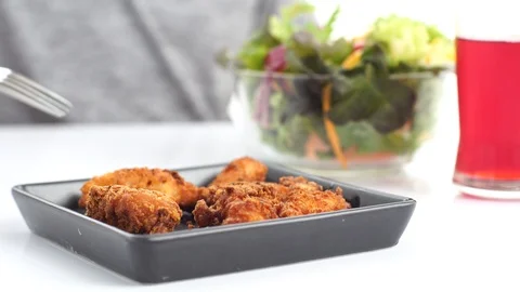 Selective focus at deep fry checken in black plate in front of mix sala Stock Footage 88437506