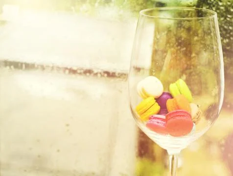 In selective focus of Different types of macaroons in motion in big wine glas Stock Photos