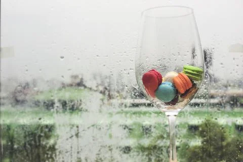 In selective focus of Different types of macaroons in motion in big wine glas Stock Photos