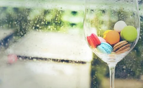 In selective focus of Different types of macaroons in motion in big wine glas Stock Photos