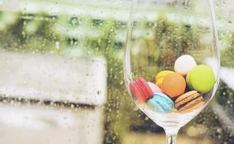 In selective focus of Different types of macaroons in motion in big wine glas Stock Photos