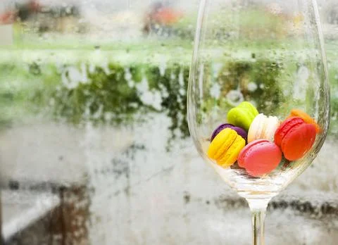 In selective focus of Different types of macaroons in motion in big wine glas Stock Photos