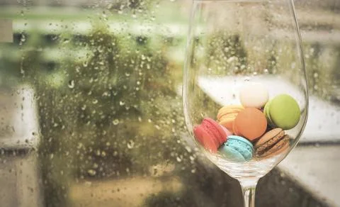 In selective focus of Different types of macaroons in motion in big wine glas 스톡 사진