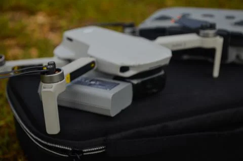 Selective focus of the DJI Mini 2 drone and remote above the bag and in nature Stock Photos