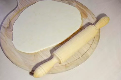 Selective focus at the dough and roller on the chopping board Stock Photos