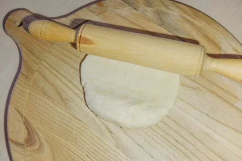 Selective focus at the dough and roller on the chopping board Stock Photos