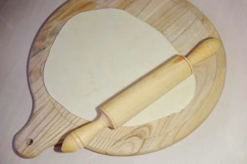 Selective focus at the dough and roller on the chopping board Stock Photos