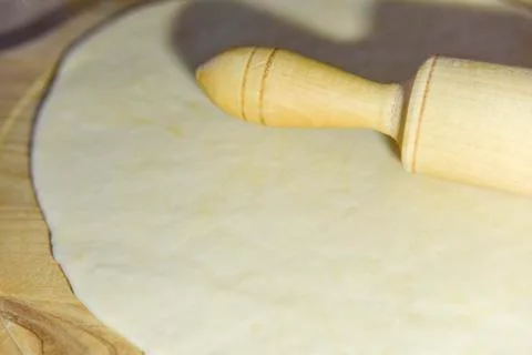 Selective focus at the dough and roller on the chopping board Stock Photos