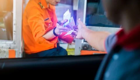 Selective focus to driver pay for the expressway. Man pays money to a cashier Stock Photos