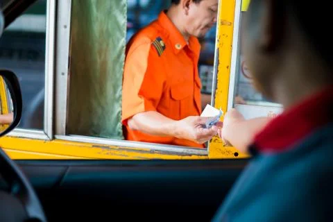 Selective focus to driver pay for the expressway. Man pays money to a cashier Stock Photos