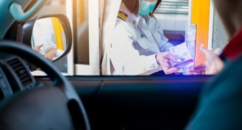 Selective focus to driver pay for the expressway. Man pays money to a cashier Foto stock