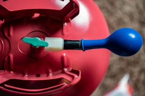 Selective focus on edge of an inflatable balloon attached to a helium canister. Stock Photos
