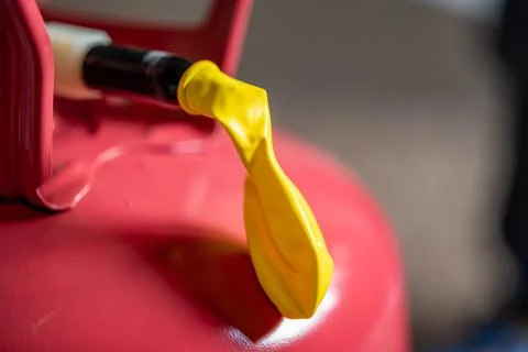 Selective focus on edge of an inflatable balloon attached to a helium canister. Stock Photos