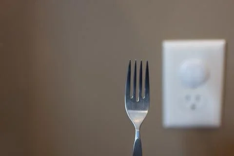 Selective focus on edge of a metal fork about to be inserted into an open Foto stock