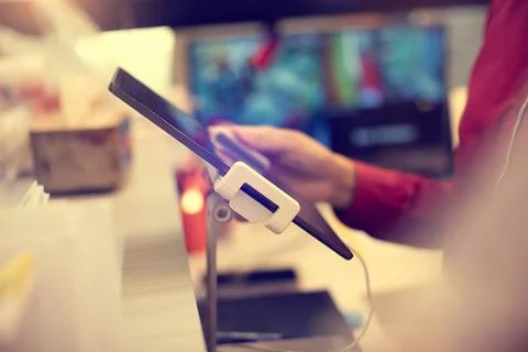 Selective focus to edge of tablet and cashier staff using it to receive ord.. Stock Photos