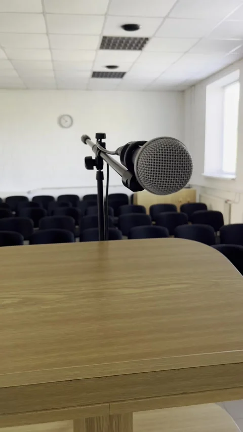 Selective focus on empty conference hall with microphone at speakers stand Stock Footage 313714054