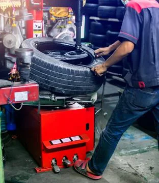 Selective focus to engineer balancing car wheel on balancer in workshop. Mech Stock Photos