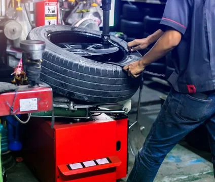 Selective focus to engineer balancing car wheel on balancer in workshop. Mech Stock Photos