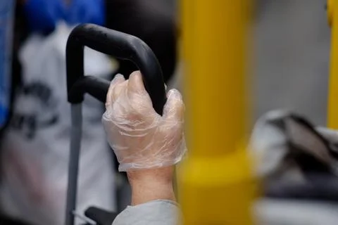 Selective focus on a female elderly hand in a plastic glove holding the handle Stock Photos