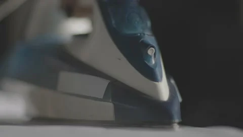 Selective focus of female hand irons white clothes with steam iron on an Ironing Stock-Footage 234592338