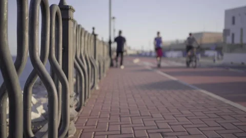 Selective focus on a fence with a blurred background Unfocused people walk ar 스톡 동영상 140799059