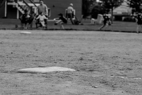 Selective focus on first base at a youth baseball field. Stock Photos