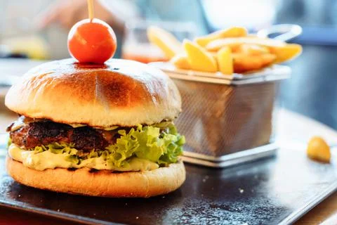 A selective focus on a fresh burger with a patty, cherry tomato and lettuce Stock Photos