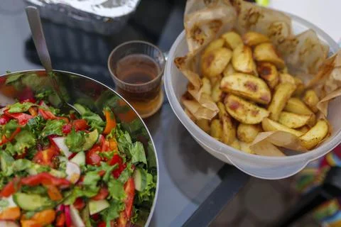 Selective focus. Fresh cut spring vegetables mixed salad, slices of oven-cooked Stock Photos