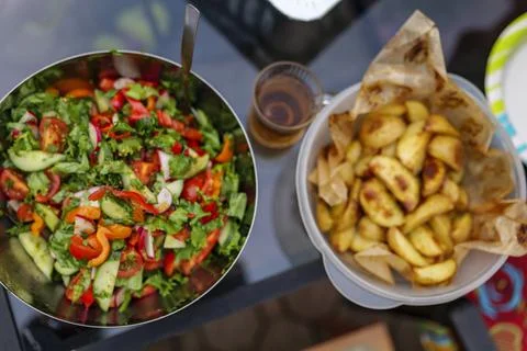 Selective focus. Fresh cut spring vegetables mixed salad, slices of oven-cooked Stock Photos