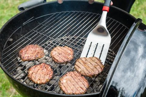 Selective focus of fresh delicious burger cutlets grilling on bbq grill Stock Photos