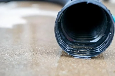 Selective focus on the front opening of a residential sump pump discharging Stock Photos