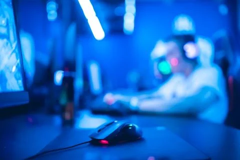Selective focus on gaming computer mouse, in background video gamer participates Stock Photos