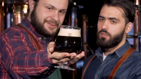 Selective focus on a glass of dark beer in hands of a brewer Stock Footage 103048238