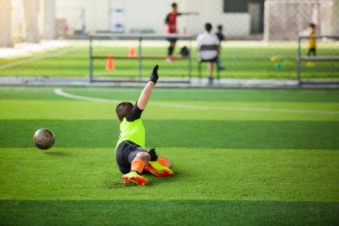 Selective focus to goalkeeper is jumping to catching the soccer ball. Blurry  Stockfoto's