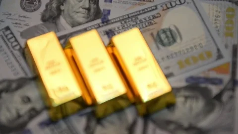 Selective focus of gold bars and dollars on a table Stock Footage 77380177