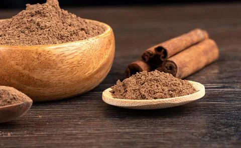 Selective focus on ground cinnamon over wooden background. Stock Photos