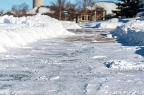 Selective focus ground level view of snow blown sidewalk section with path Stock Photos